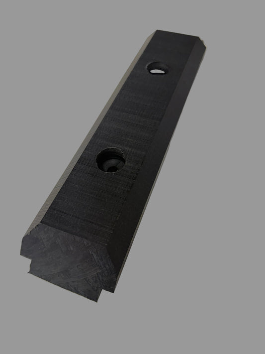 Studio photograph of a long black industrial composite wear plate on a neutral grey background featuring two recessed circular mounting holes and a beveled edge with a textured matte finish